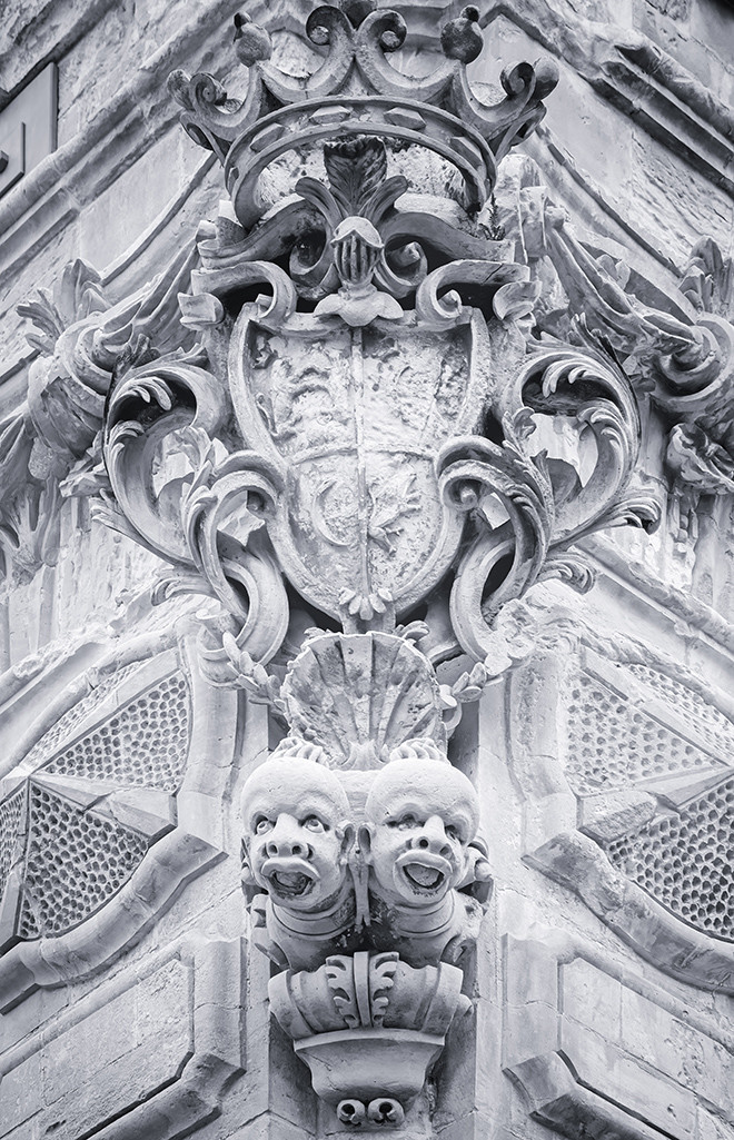 Black and white photo of Sicilian Baroque decoration on a palazzo in Scicli Sicily. 