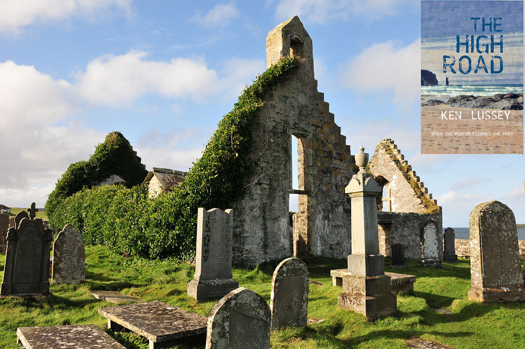 The image shows a corner view of a ruined T-shape church whose walls are still standing but which is roofless. The long wall on its left is entirely covered in ivy while other walls are more visible. There are gravestones in the foreground set amongst rough grass. The sea can be glimpsed on the right. The scene is in sunlight. The front cover of ‘The High Road’ is shown in the top right corner.