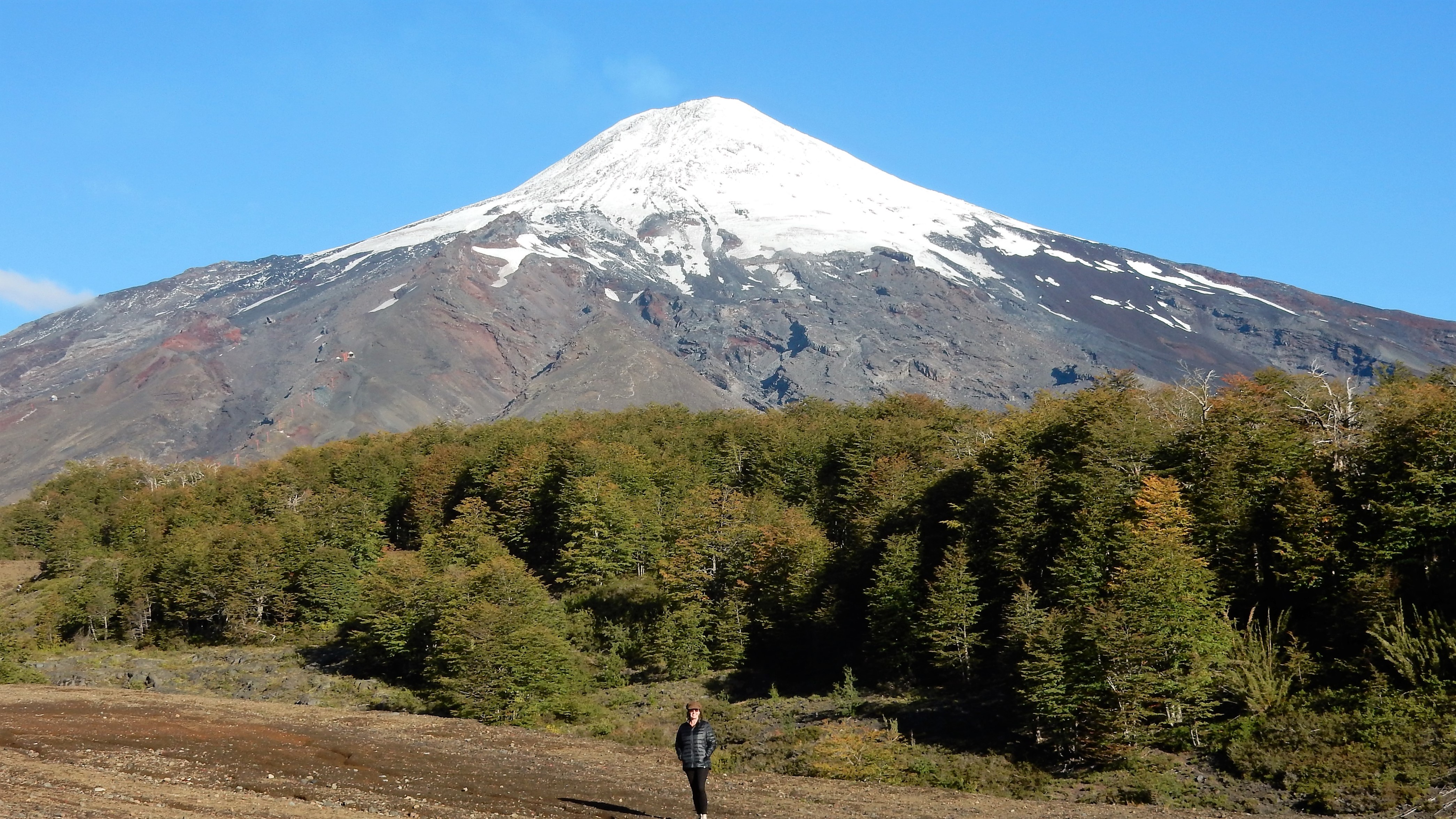 Me standing at the base of a snow capped cone volcano. If you look close you can see the gas/smoke rising from the top of the cone.