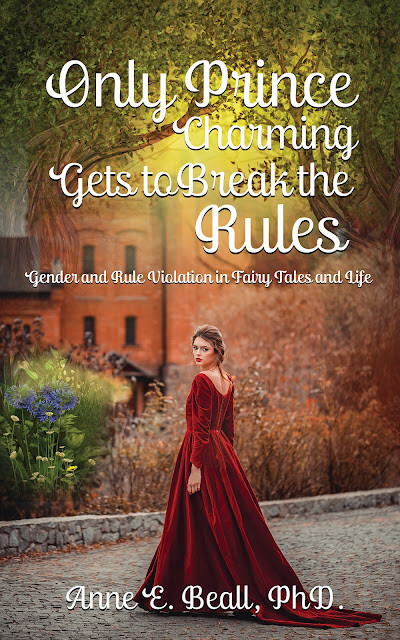 A wistful young woman wearing a medieval styled red velvet dress. She is looking back over her shoulder towards us. She is standing on a path in front of an old red brick building with flowers in the verge at the edge of the path.