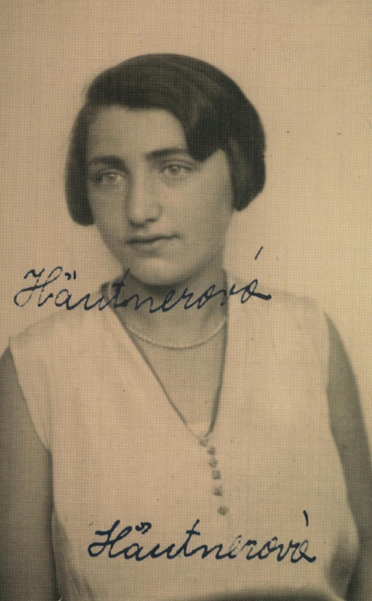 A woman ID portrait photo. She is wearing a white blouse with no sleaves and a pearl beads.