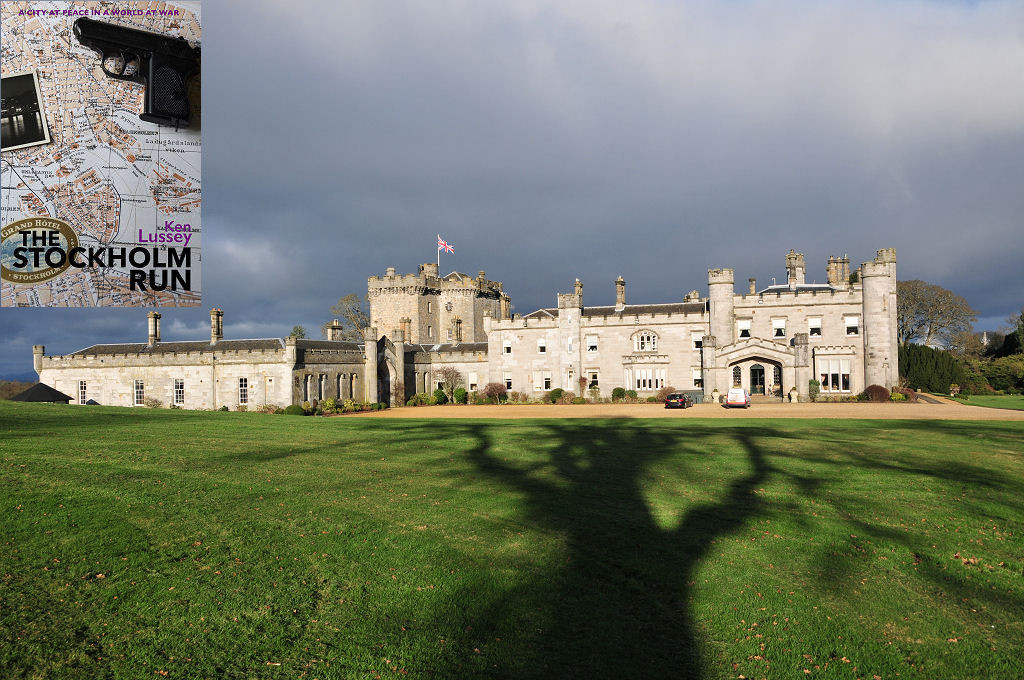 The image shows a frontal view of Dundas Castle in bright sunlight, though under dark skies. There’s a long shadow of a tree extending out across the grass in the foreground towards the castle. The front cover of 'The Stockholm Run' is shown in the top left corner.