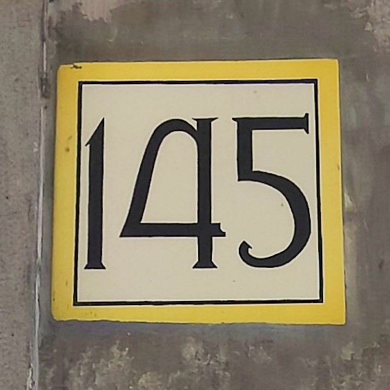 The number 145 painted with serifs. The number 4 is closed in the top, but it is rounded rather than pointed.