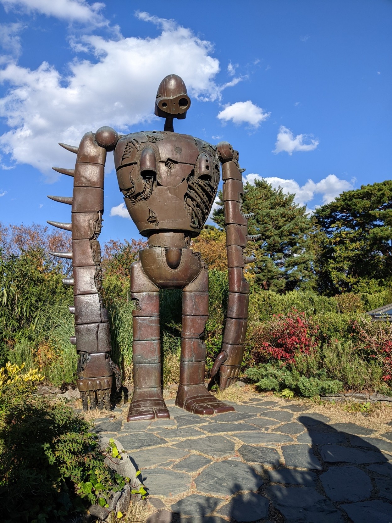 The giant from Castle in the Sky on the rooftop at Ghibli park. Blue sky with clouds abive