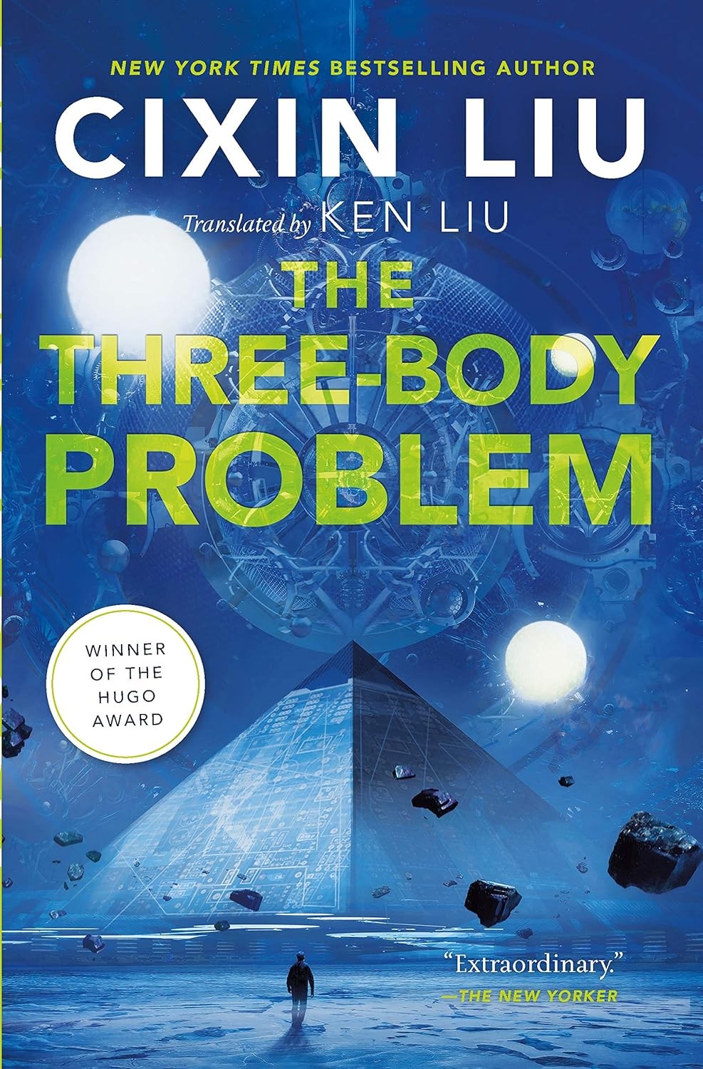 The Three-Body Problem by Cixin Liu.

The book cover is done in shades of blue and depicts the tiny figure of a man walking towards a pyramid. Above it are three celestial bodies orbiting the outline of a planet. Superimposed over that is the title of the book in bold yellow block print. The author's name is in large white print at the top of the cover. Taken together the cover perfectly encapsulates the science fiction, intrigue and mind-bending nature of the novel.