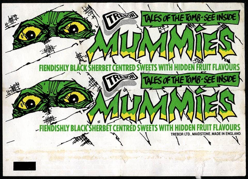 a wrapper of the popular 1980s UK sweet Mummies which features glowing green eyes in a dead face peering through bandages 