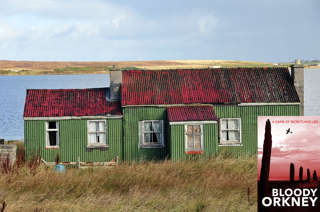 This modern image shows a tin cottage on the island of Hoy in Orkney. We are looking slightly downhill towards it over long grass. The cottage has green corrugated walls on a main section on the right with two white windows and a porch, and a smaller section on the left with two windows. The building is weatherbeaten, especially its red corrugated roof. There is water in the background and land in the distance. The front cover of ‘Bloody Orkney’ is shown in the bottom right corner.