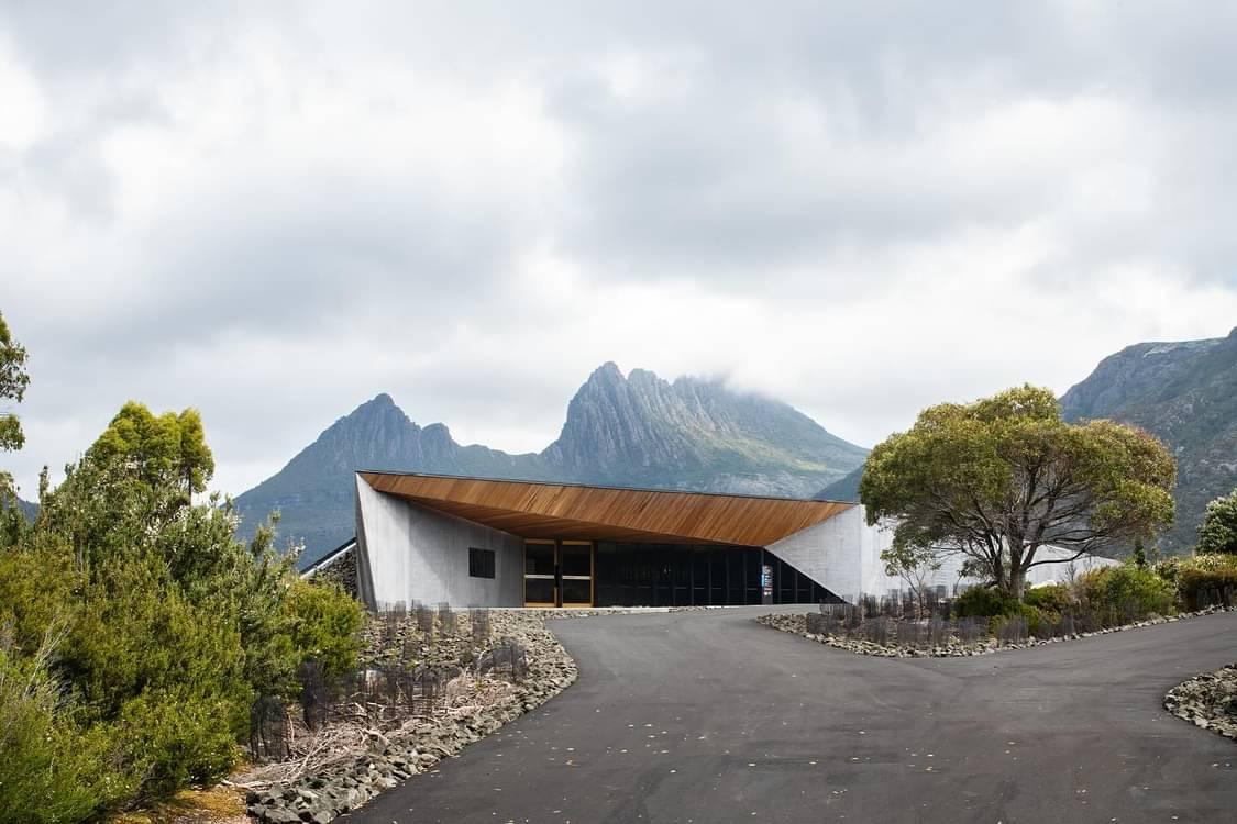 The building from outside. It is geometic. Reminiscent of Corbusier’s Notre-Dame du Haut. The ominious shape of Cradle mountain looms over it from the distance. 