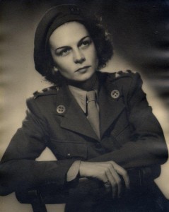 black and white studio portrait of Jacqueline Nearne in her First Aid Nursing Yeomanry uniform. She is a white woman with dark hair.