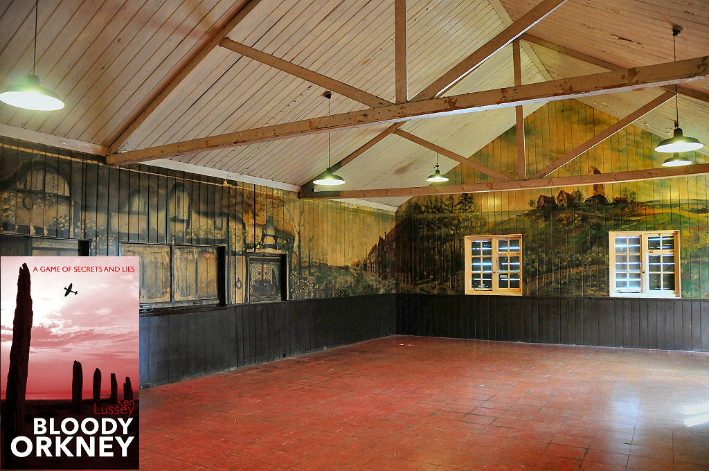 This modern image shows some of the murals painted in the mess hall during the war. The ceiling is off-white and supported by trusses and the floor is red. The lower walls are dark brown, but the upper walls are entirely covered by rural English scenes. The front cover of ‘Bloody Orkney’ is shown in the bottom left corner.