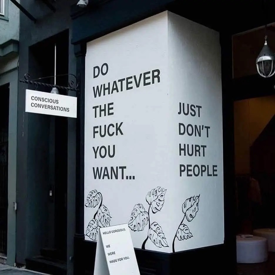 A photo of a poster outside a cafe. text reads, "do whatever the fuck you want... just don't hurt people."