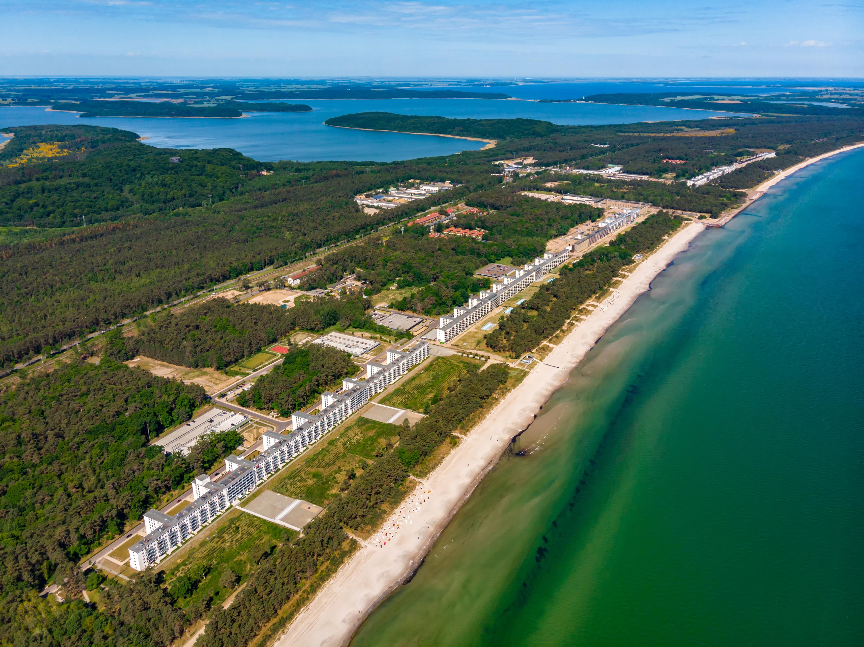 airphoto of Prora. Long beech with the massive building. Green surroundings.

source: https://en.wikipedia.org/wiki/Prora#/media/File:20-07-06-Prora-RalfR-DJI_0120.jpg