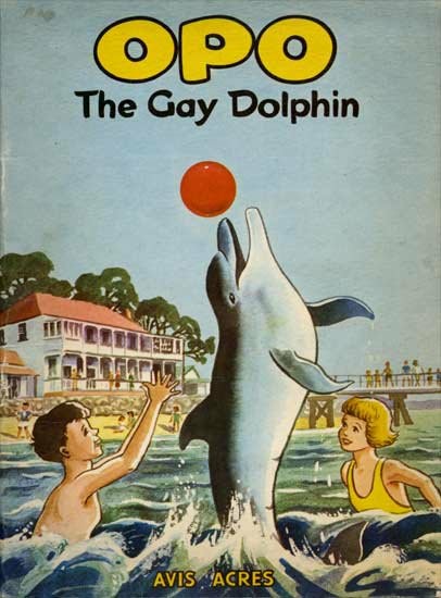 The cover of a book titled Opo The Gay Dolphin. An illustration of a dolphin leaping out of the sea, thrusting at a red ball with its nose. Two human children frolic in the sea and watch the dolphin with glee.