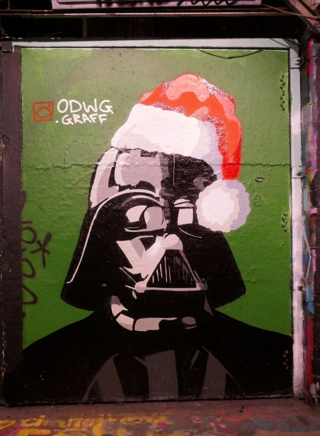 Streetartwall. A rather unconventional Santa Claus was spray-painted on a wall in an old tunnel full of street art and graffiti. On a green background, Darth Vader from Star Wars can be seen with a red Christmas cap on his helmet. A male figure with a menacing-looking helmet mask. A kind of combination of a black German SS helmet and a square gas mask. 
Note: His famous line from the movie is: "No, I'm your father", or was it "Luke, I'm your Santa"?