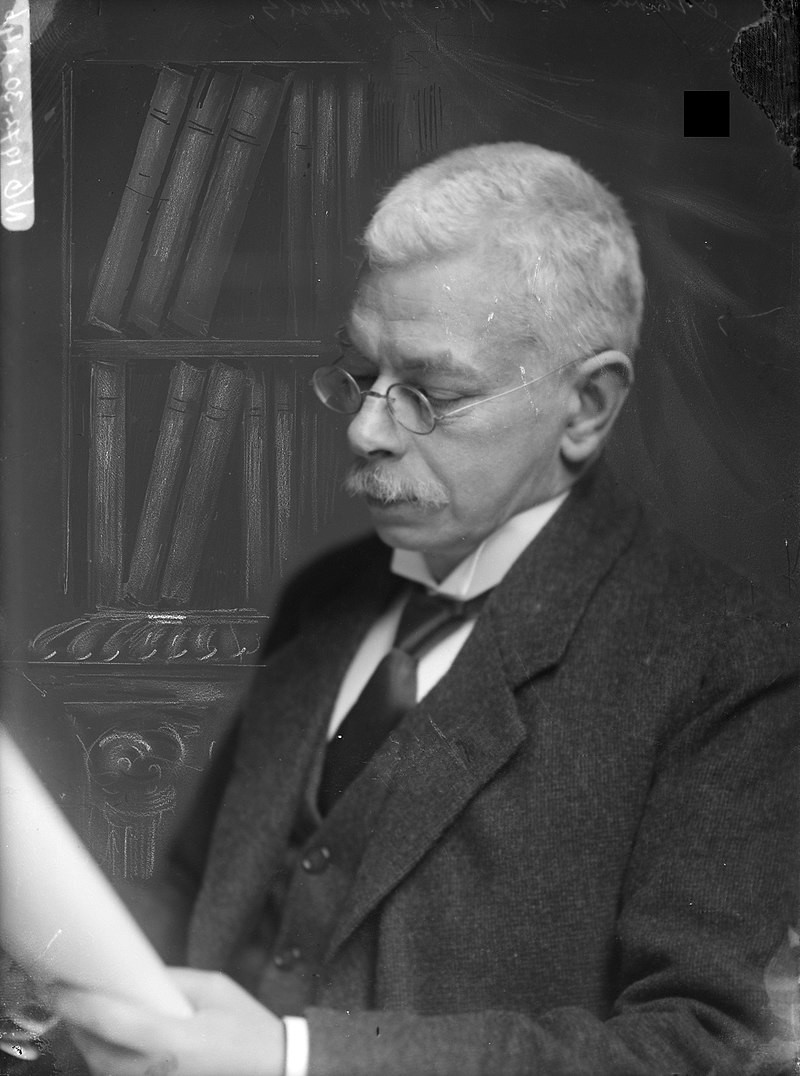 Portrait of Dr Pieter Zeeman (1865-1943) Professor of Physics. Document type photograph Creator Merkelbach, Atelier J. Collection Collection Atelier J. Merkelbach Portrayed Zeeman, P. (Pieter,1865-1943) 
Inventories http://archief.amsterdam/archief/10164/35264 Image file 010164033015

 A senior gentleman in spectacles and formal attire reading a book.