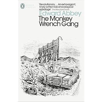 The  cover of the book "The Monkey Wrench Gang" by Edward Abbey.

The author's name is in a gray camel case typeface against a white background.
The title is in a black camel case typeface

The cover illustration is a black and white hand drawn illustration of a man with a petrol can setting fire to  a bill-board. 
There is a limosine parked at the roadside next to the bill-board.
There are hills in the background

* Another Duchess of Spring Alt-text production ™