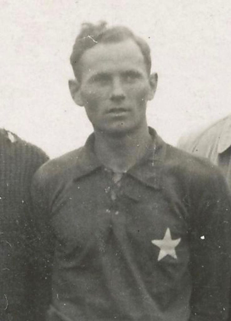 A man standing among others. He is wearing a football shirt and has a five-arm star on his chest - it was a symbol of Wisla Krakow football club (the white star)