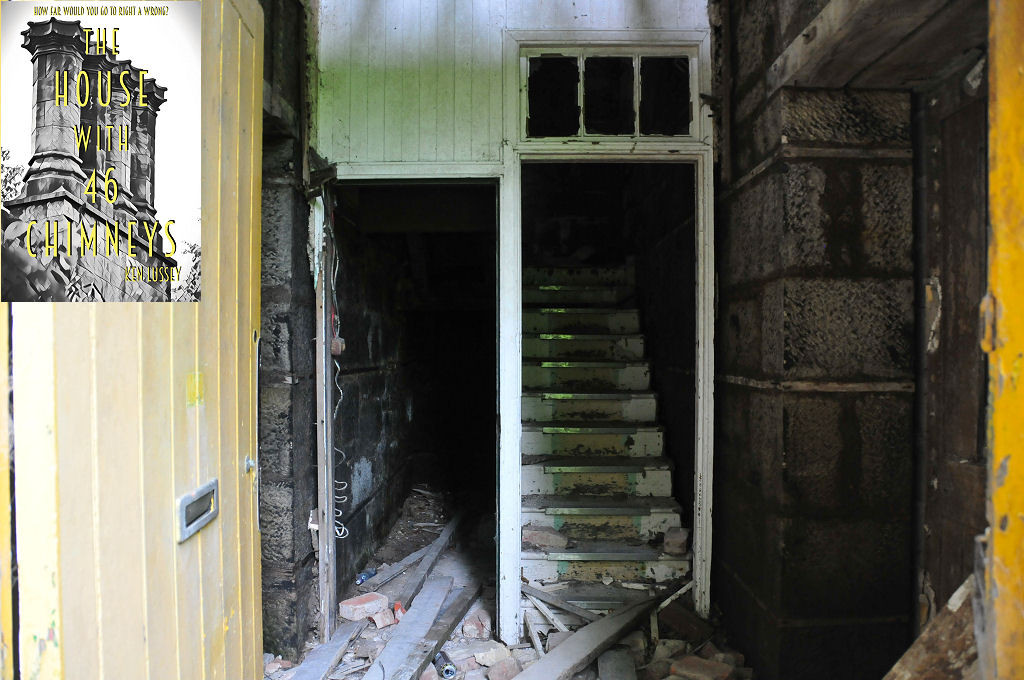 The image shows a faded yellow door standing open on the left, with part of its doorframe on the right. Beyond is a stone hallway with debris on the ground and closed doors on both sides. Dirty white wooden panelling provides a doorway to the further part of the hall, and to a set of steps leading upwards into darkness. The front cover of ‘The House With 46 Chimneys’ is shown in the top left corner.