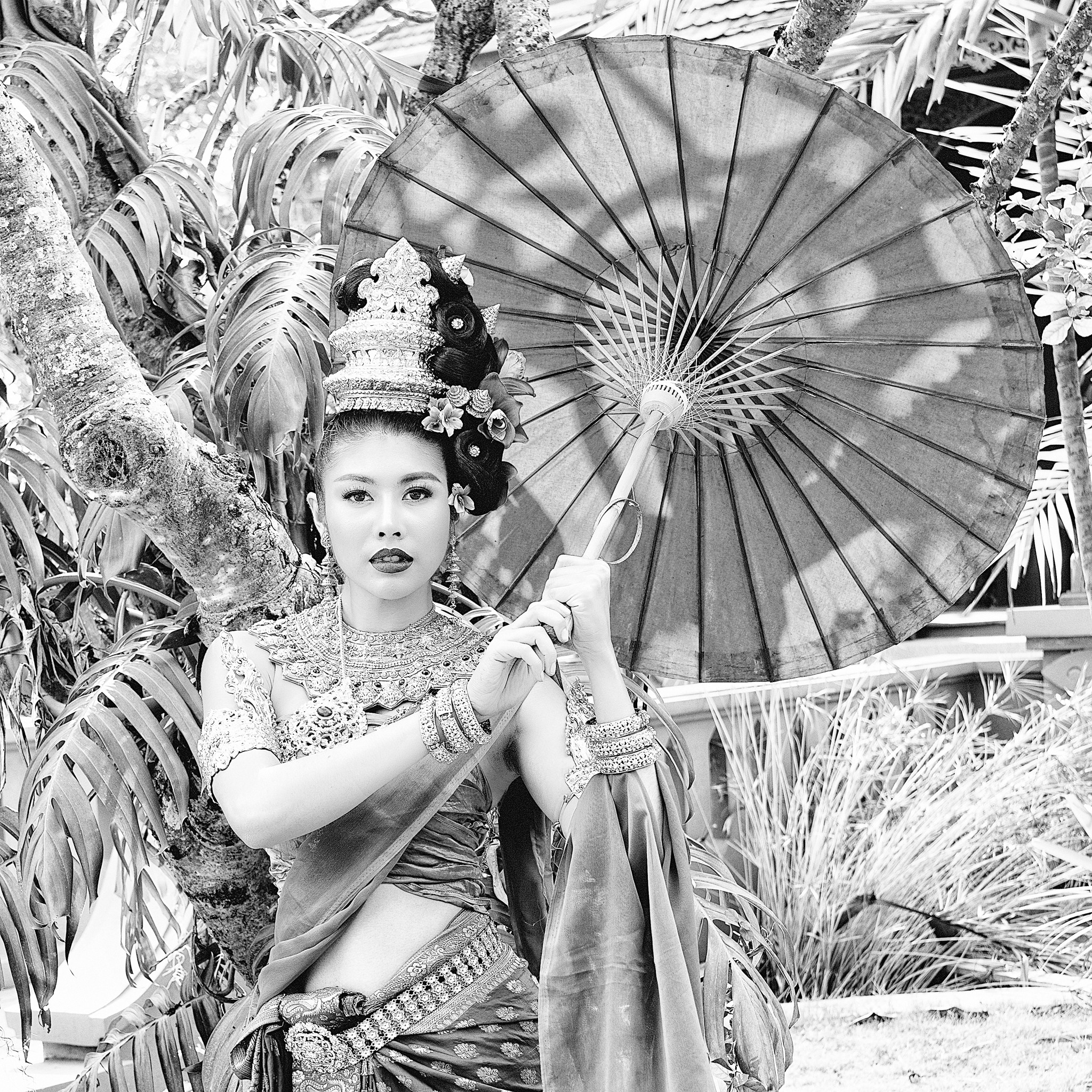 Woman in traditional Thai costume holding a parasol 