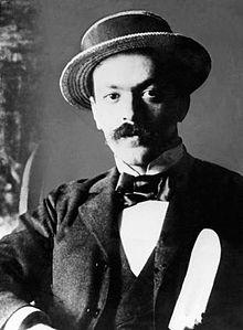 Italo Svevo with the preliminary draft of A Life (1892).

Svevo is depicted as a refined, intellectual figure. He has a well-groomed mustache and an intense, thoughtful gaze, reflective of his literary persona and introspective writing style.

Svevo is dressed in formal, period-appropriate clothing, including:
A dark suit jacket and waistcoat.

A white shirt and bow tie, which enhance the formality of his appearance.

A stylish boater hat, which adds a touch of elegance and aligns with late 19th-century European fashion trends.