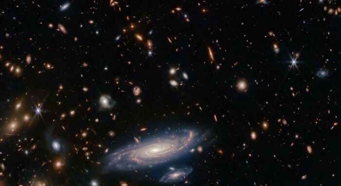 The big galaxy in the foreground is named LEDA 2046648, and is seen just over a billion years back in time, while most of the others lie even farther away, and hence are seen even further back in time. ESA/Webb, NASA & CSA, A. Martel.