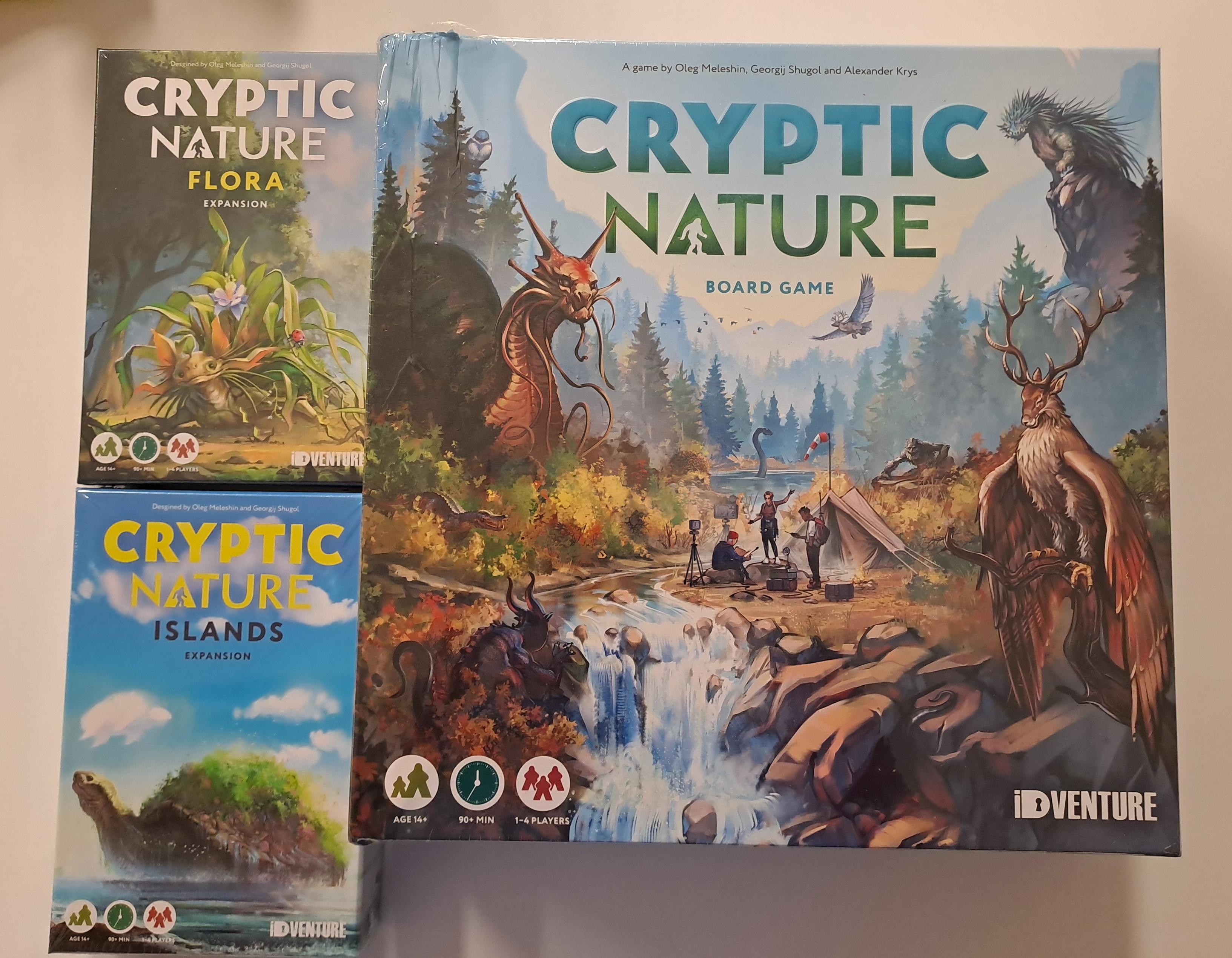 A large colorful board game box featuring art of verious cryptid creatures in mountain scenery. The title of the game is Cryptic Nature. Next to it are two smaller boxes, one titled Cryptic Nature: Flora and one titled Cryptic Nature: Islands. They are expansions for the game. Info tags on the box say the game is for ages 14+, takes 90+ minutes, and can have 1-4 players.