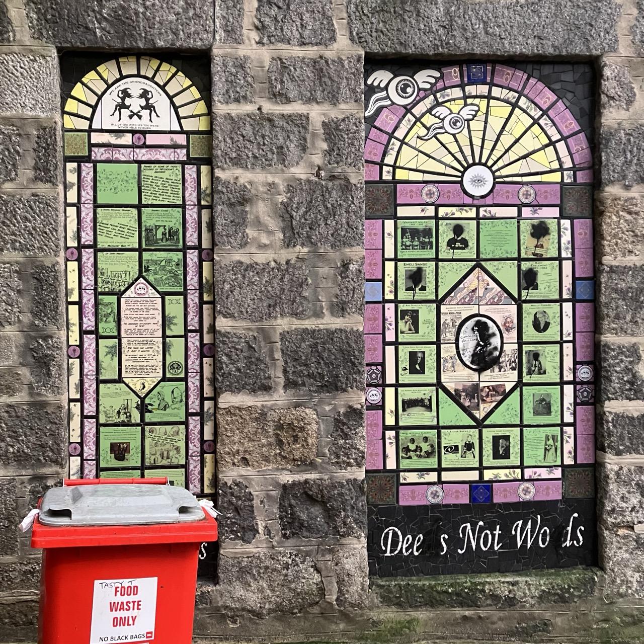 A picture of two tile mural panels that look like Xerox zines, with medieval woodcuts next to pictures of modern women’s faces and other clip art type images of women on brooms and flying eyeballs. 