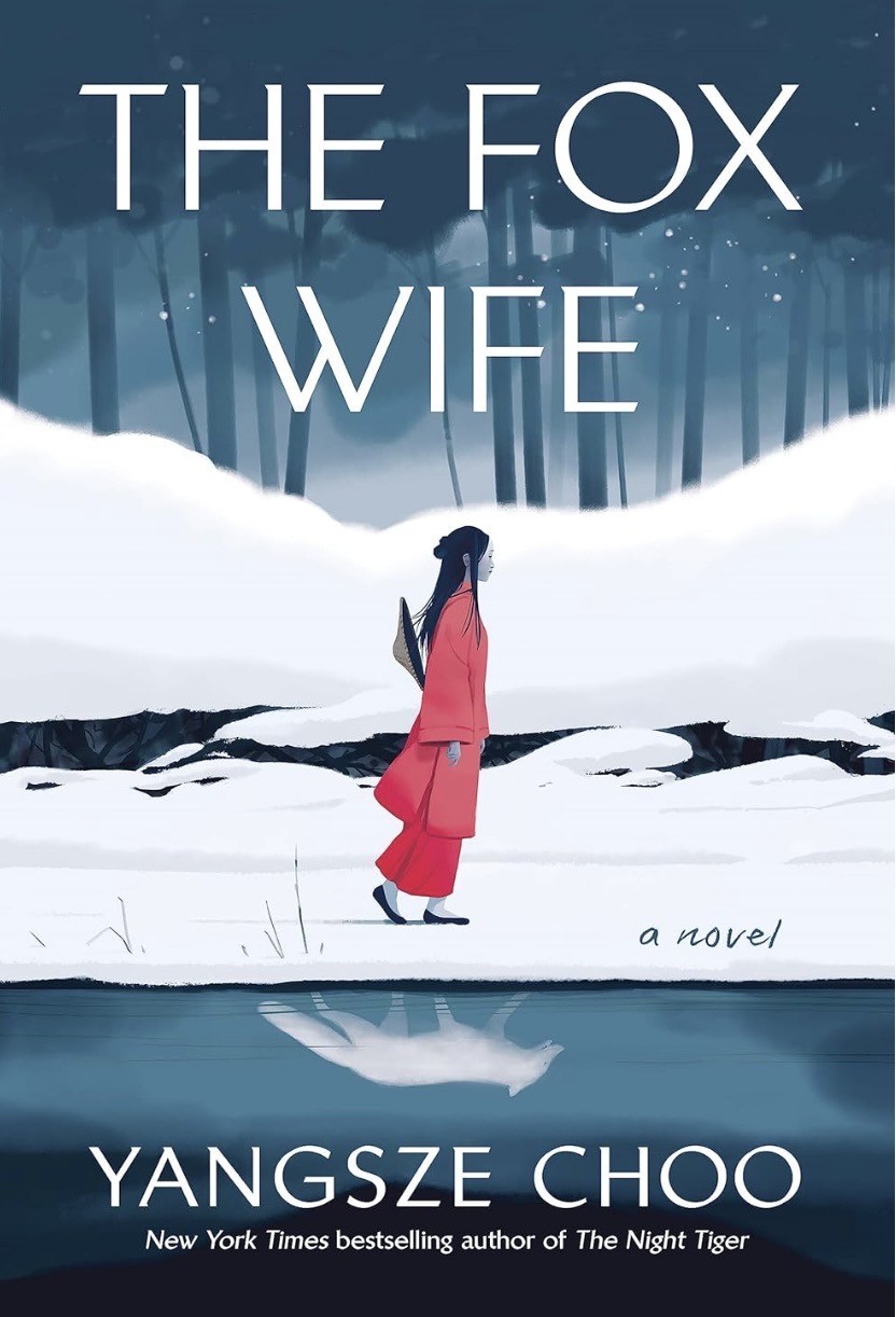 Book Cover of The Fox Wife by Yangsze Choo. A Chinese Woman in a long red jacket and red trousers and with a bamboo hat on her back walks in a snowy landscape. Her reflection isn’t a woman, but a white fox. 