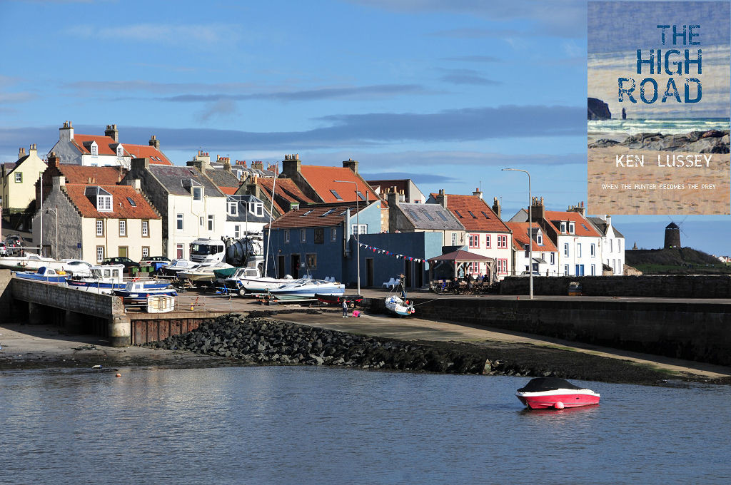 The image shows a view across a harbour to a pier and slipway and then to a village of mainly white houses and a blue restaurant. Most buildings have red pantiles on their roofs. There are numerous small boats pulled up at the top of the slipway and one red speedboat is moored in the harbour. There is bright sunlight on most of the scene, though a windmill along the shore is in shadow. The front cover of ‘The High Road’ is shown in the top right corner.